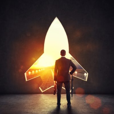 Concept of startup with a rocket shape hole in the wall which alludes to the departure towards new goals Hole in the wall overlooking a runway at sunset