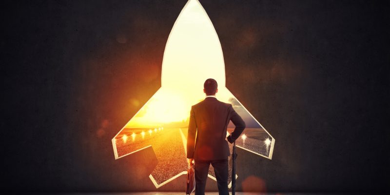 Concept of startup with a rocket shape hole in the wall which alludes to the departure towards new goals Hole in the wall overlooking a runway at sunset